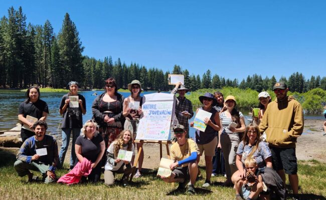 Journaling attendees show their full notebooks of observations at Manzanita Lake. Photo © J. Malik. July 20, 2025.
