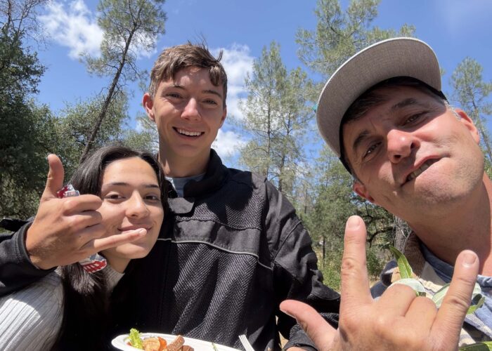 Jeremey does a "rock on" hand sign in a selfie with attendees. Photo by J. Kelley.