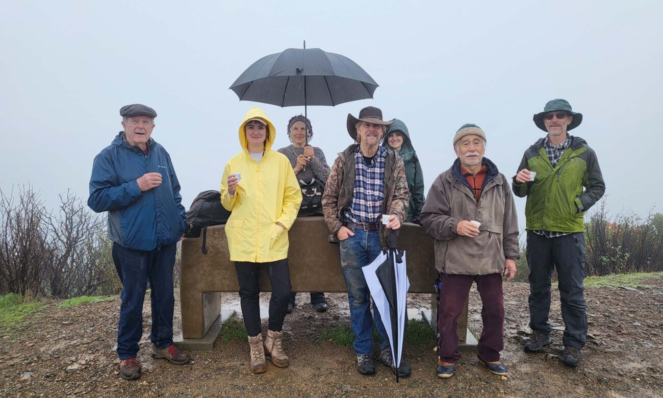 Seven hikers posse in the rain at the Top of the World. January 1, 2026. D. Mandel.