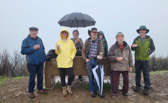 Seven hikers posse in the rain at the Top of the World. January 1, 2026. D. Mandel.