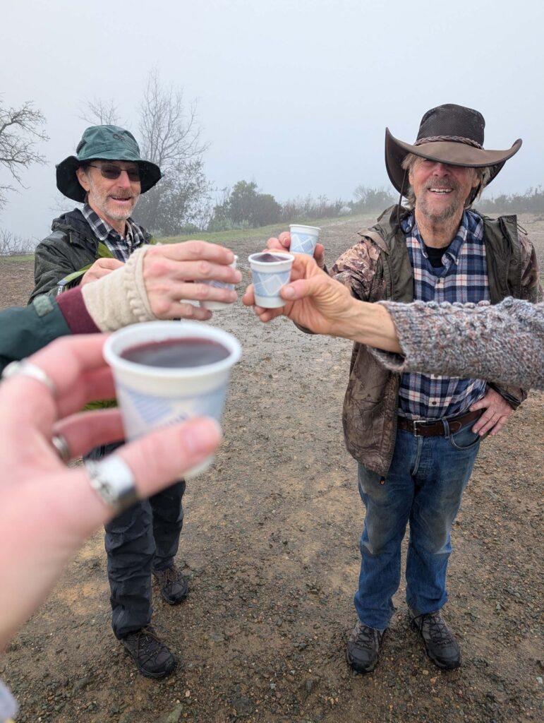 Hikers say "Cheers" at the pinnacle of their hike. On the trail to Top of the World. January 1, 2026. R. Redlich.