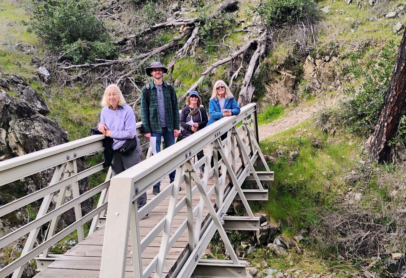 Hikers on bridge over creek. D. Ledger.